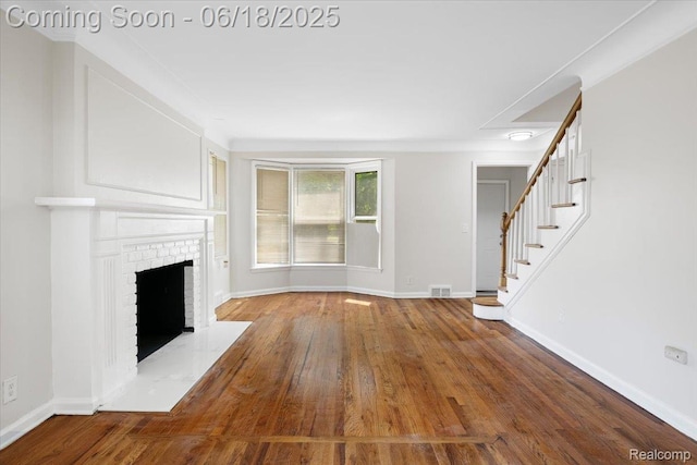 11108 Craft St, Detroit, MI 48224 - unfurnished living room featuring wood finished floors, stairway, and a fireplace