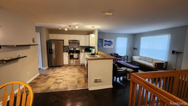 870 Lothrop Rd Unit 6/1, Detroit, MI 48202 - kitchen featuring stainless steel appliances, decorative backsplash, white cabinetry, pendant lighting, and under cabinet range hood