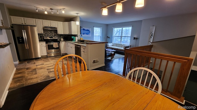 870 Lothrop Rd Unit 6/1, Detroit, MI 48202 - kitchen featuring appliances with stainless steel finishes, under cabinet range hood, a peninsula, backsplash, and white cabinets