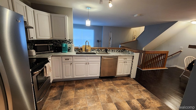 870 Lothrop Rd Unit 6/1, Detroit, MI 48202 - kitchen featuring stainless steel appliances, white cabinetry, a peninsula, dark stone finish flooring, and backsplash
