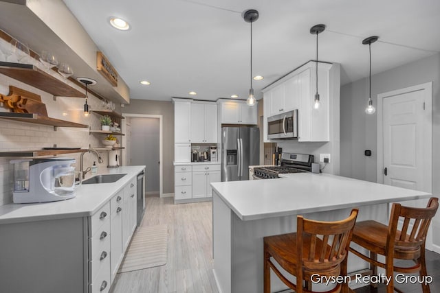 431 Homecrest Ave, Kalamazoo, MI 49001 - kitchen featuring appliances with stainless steel finishes, a peninsula, a breakfast bar, light countertops, and decorative backsplash