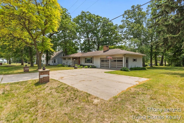 11737 W Carson City Rd, Greenville, MI 48838 - view of front of home with a garage, a front yard, concrete driveway, and a chimney