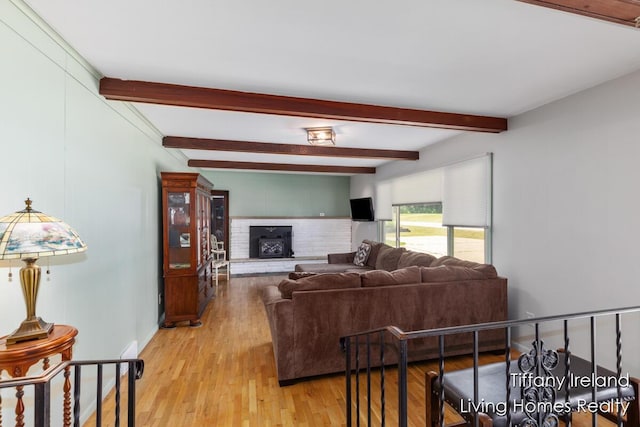 11737 W Carson City Rd, Greenville, MI 48838 - living area featuring beamed ceiling, light wood-style floors, and a fireplace