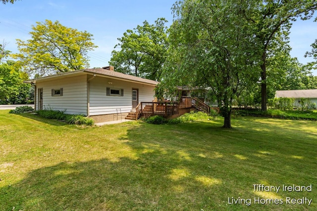 11737 W Carson City Rd, Greenville, MI 48838 - view of grassy yard featuring a wooden deck and stairway