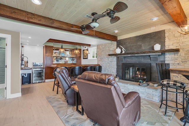 11786 E Sauk Trl, Jerome, MI 49249 - living area featuring beverage cooler, a wooden ceiling with exposed beams, light wood-type flooring, bar, and a fireplace