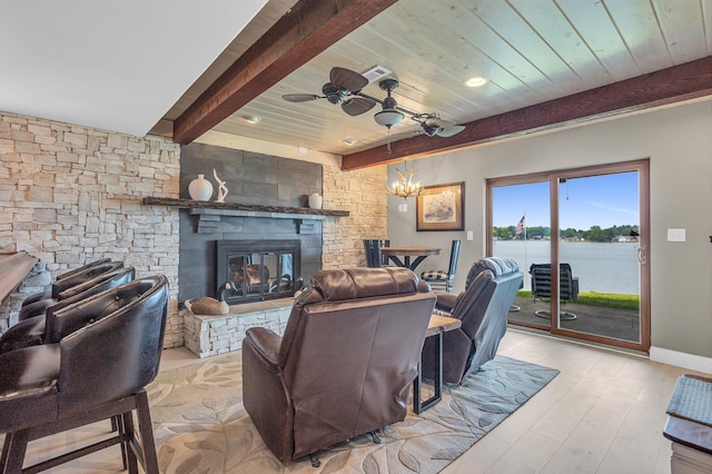 11786 E Sauk Trl, Jerome, MI 49249 - living room with ceiling fan, a stone fireplace, wood finished floors, a water view, and a chandelier