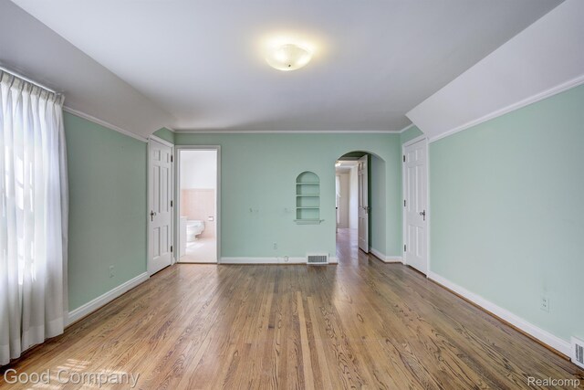 20 Oxford Blvd, Pleasant Ridge, MI 48069 - spare room featuring arched walkways, built in shelves, wood finished floors, and crown molding