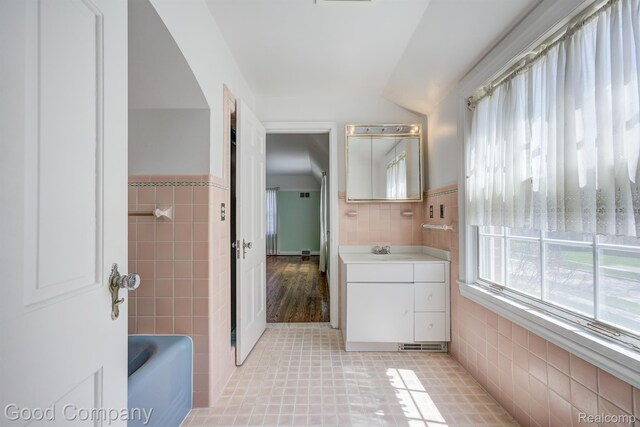 20 Oxford Blvd, Pleasant Ridge, MI 48069 - bathroom featuring vanity, lofted ceiling, a tub to relax in, tile walls, and tile patterned floors