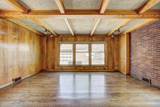 20 Oxford Blvd, Pleasant Ridge, MI 48069 - empty room with track lighting, hardwood / wood-style flooring, beam ceiling, wooden walls, and brick wall