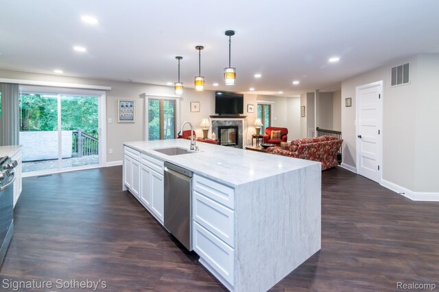 23415 Beech Rd, Southfield, MI 48033 - kitchen with stainless steel dishwasher, open floor plan, a glass covered fireplace, recessed lighting, and white cabinetry