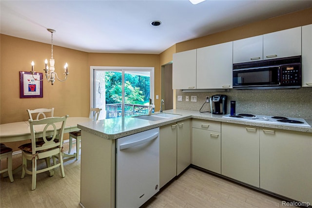 6760 Oyster Cv, West Bloomfield, MI 48323 - kitchen with white appliances, light countertops, a chandelier, decorative backsplash, and a peninsula