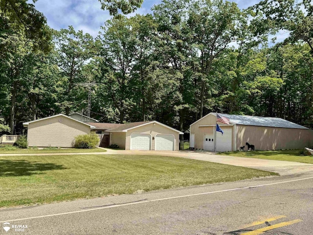 449 Noric Dr, Roscommon, MI 48653 - ranch-style home with a detached garage, a front yard, an outbuilding, and view of scattered trees
