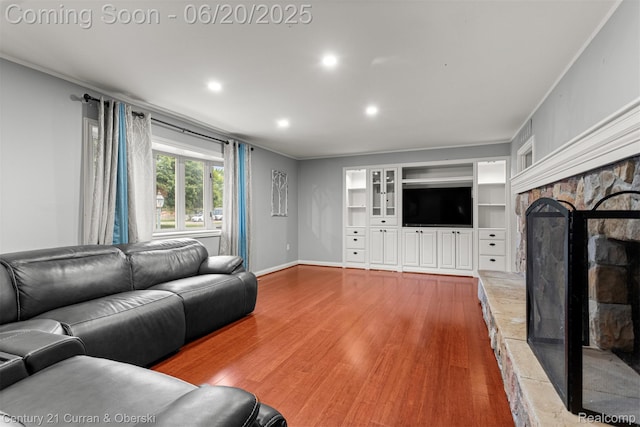 2138 Metzner Rd, Commerce Twp, MI 48390 - living room featuring wood finished floors, a stone fireplace, built in shelves, and recessed lighting