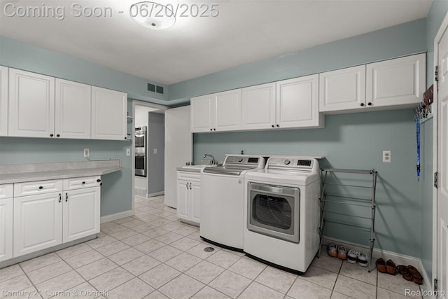 2138 Metzner Rd, Commerce Twp, MI 48390 - washroom featuring washer and dryer, cabinet space, and light tile patterned flooring