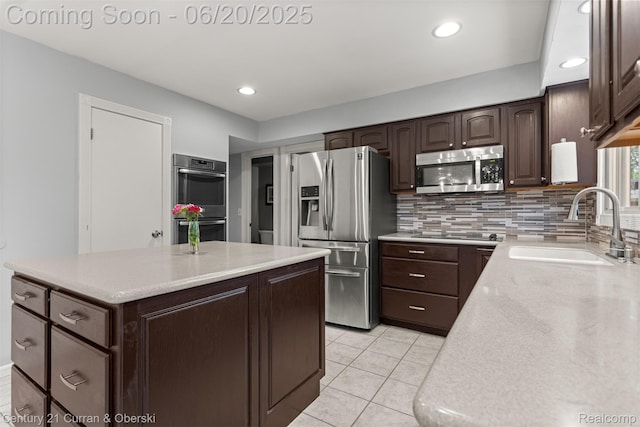2138 Metzner Rd, Commerce Twp, MI 48390 - kitchen featuring appliances with stainless steel finishes, dark brown cabinets, backsplash, a kitchen island, and light tile patterned floors
