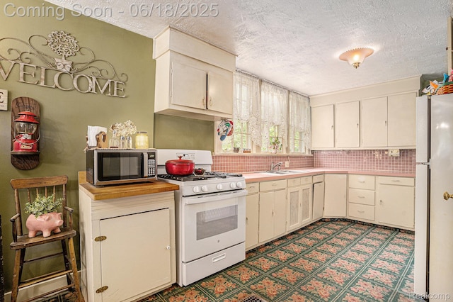 44988 52nd St, Lawrence, MI 49064 - kitchen with white appliances, a textured ceiling, light countertops, dark floors, and backsplash