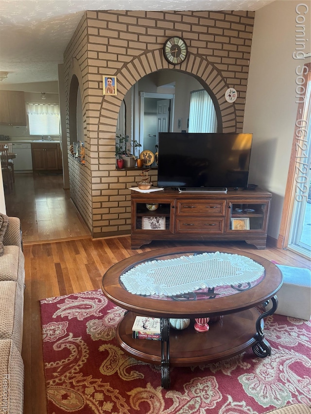 8311 Gulley St, Taylor, MI 48180 - living area with wood finished floors, arched walkways, healthy amount of natural light, and a textured ceiling