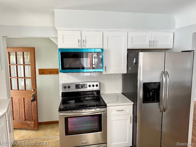 22902 Olmstead St, Dearborn, MI 48124 - kitchen with appliances with stainless steel finishes, white cabinets, backsplash, and light stone counters