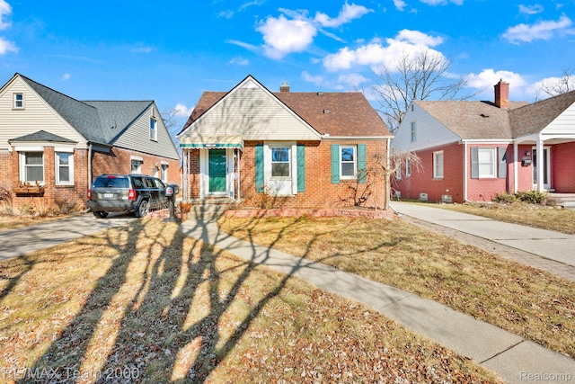 22902 Olmstead St, Dearborn, MI 48124 - bungalow-style house with driveway, brick siding, a front lawn, and a chimney