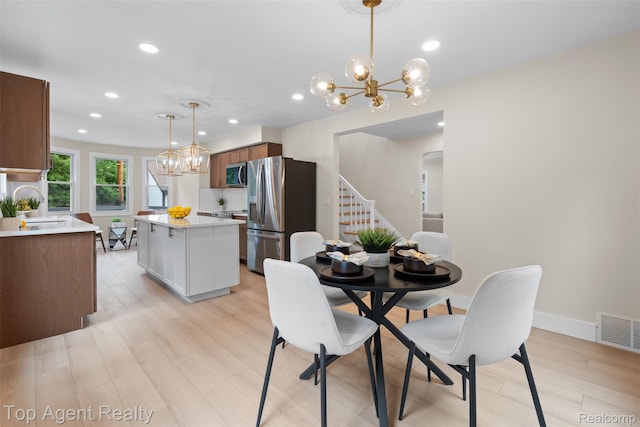 14638 Greenview Rd, Detroit, MI 48223 - dining area with a chandelier, stairway, recessed lighting, light wood-style flooring, and arched walkways