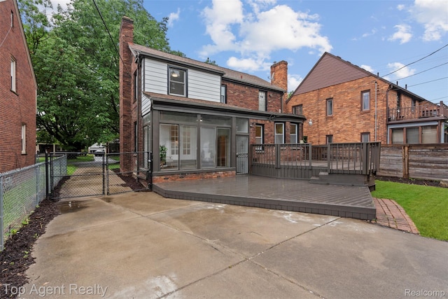 14638 Greenview Rd, Detroit, MI 48223 - back of house with a chimney, a gate, a fenced backyard, a wooden deck, and brick siding