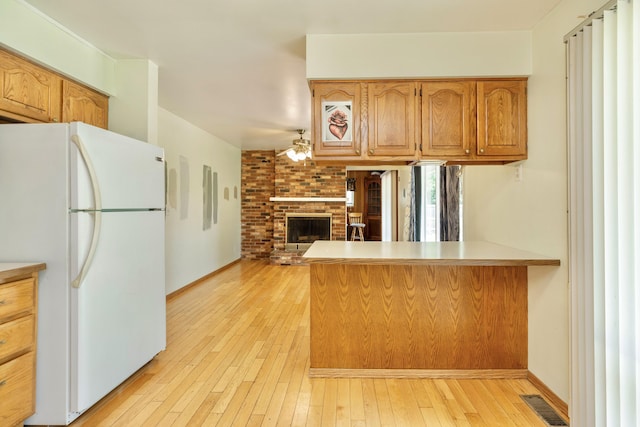 531 Gettysburg Dr, Niles, MI 49120 - kitchen with freestanding refrigerator, a peninsula, light wood-style floors, a fireplace, and open floor plan