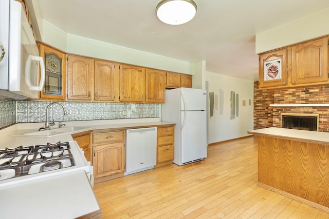 531 Gettysburg Dr, Niles, MI 49120 - kitchen featuring white appliances, light countertops, tasteful backsplash, light wood-type flooring, and a fireplace
