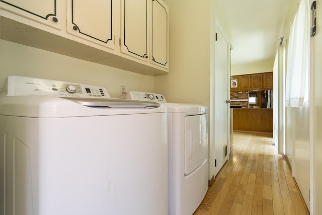 531 Gettysburg Dr, Niles, MI 49120 - laundry room featuring washing machine and clothes dryer, light wood finished floors, and cabinet space