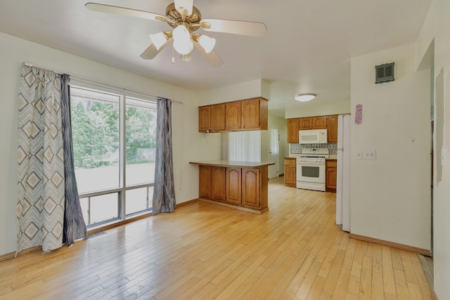 531 Gettysburg Dr, Niles, MI 49120 - kitchen with white appliances, a peninsula, brown cabinetry, light wood-type flooring, and a ceiling fan