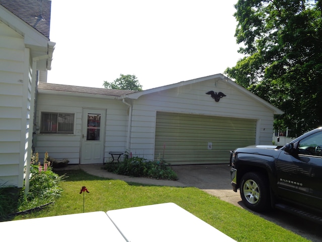 205 Prentiss St, Allen, MI 49227 - view of side of property with an attached garage, concrete driveway, and roof with shingles