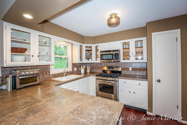 6072 Del Cano Dr SE, Grand Rapids, MI 49546 - kitchen with stainless steel appliances, tile counters, white cabinetry, and backsplash