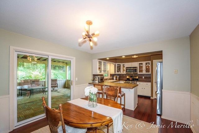 6072 Del Cano Dr SE, Grand Rapids, MI 49546 - dining area with a chandelier, wainscoting, and dark wood-style floors