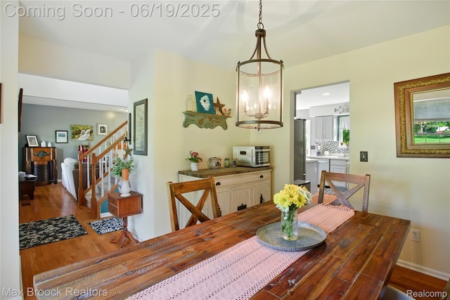 7950 Sandmar Ln, Davisburg, MI 48350 - dining space with wood finished floors, stairway, and a chandelier