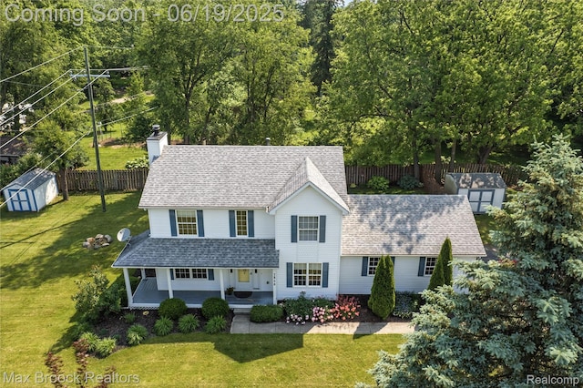 7950 Sandmar Ln, Davisburg, MI 48350 - view of front of house with a shed, roof with shingles, a chimney, and covered porch