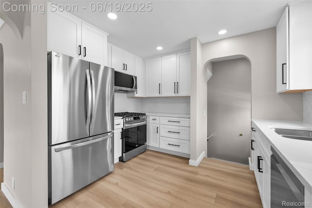 8171 Marian St, Warren, MI 48093 - kitchen with stainless steel appliances, arched walkways, light wood finished floors, tasteful backsplash, and recessed lighting