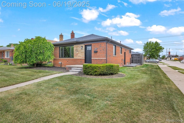 8171 Marian St, Warren, MI 48093 - view of front of home with brick siding, a chimney, a front yard, and roof with shingles
