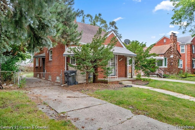 13631 Vassar Ave, Detroit, MI 48235 - view of front facade with brick siding, a gate, covered porch, and driveway