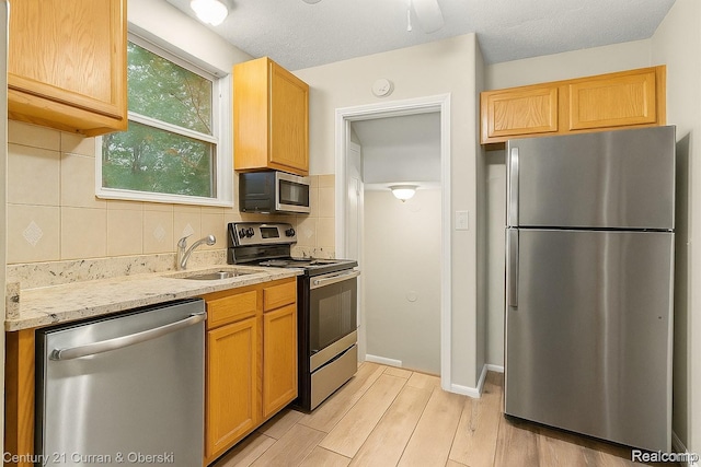 13631 Vassar Ave, Detroit, MI 48235 - kitchen featuring appliances with stainless steel finishes, backsplash, light stone counters, and light wood-style flooring