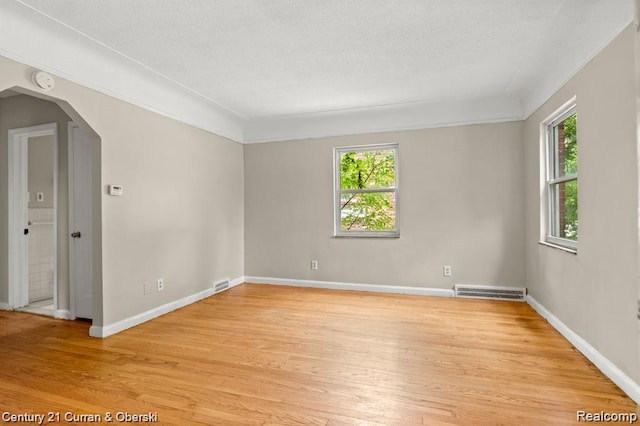 13631 Vassar Ave, Detroit, MI 48235 - unfurnished room with arched walkways, plenty of natural light, light wood finished floors, and a textured ceiling