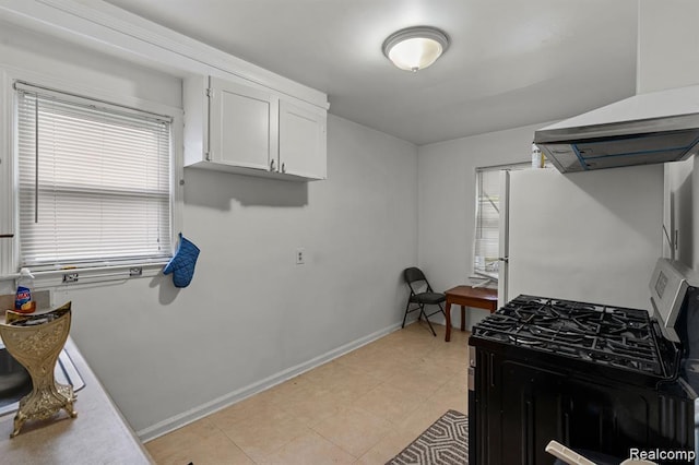 17041 Henry St, Melvindale, MI 48122 - kitchen featuring gas range oven, white cabinets, freestanding refrigerator, and wall chimney exhaust hood
