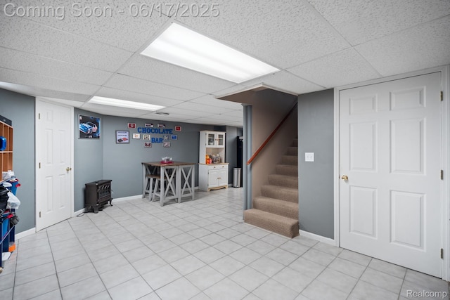 24462 Christian Dr, Flat Rock, MI 48134 - finished basement with a paneled ceiling, stairway, and a wood stove