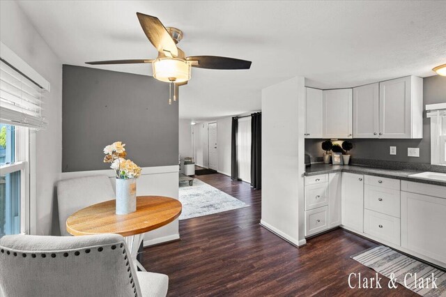 1873 Veronica St SE, Lowell, MI 49331 - kitchen with dark wood-style floors, ceiling fan, white cabinets, and dark countertops