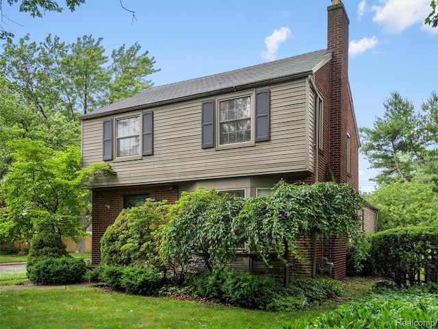 1930 Kenmore Dr, Grosse Pointe Woods, MI 48236 - view of front of home with a chimney, a front lawn, and brick siding