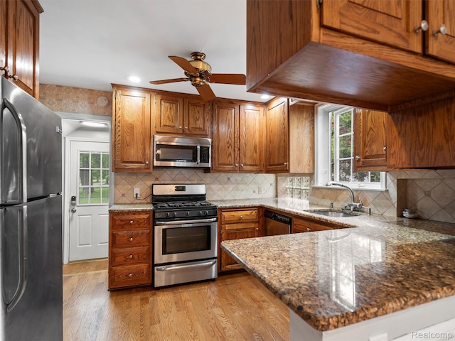 1930 Kenmore Dr, Grosse Pointe Woods, MI 48236 - kitchen with appliances with stainless steel finishes, a ceiling fan, light wood-type flooring, a peninsula, and dark stone countertops