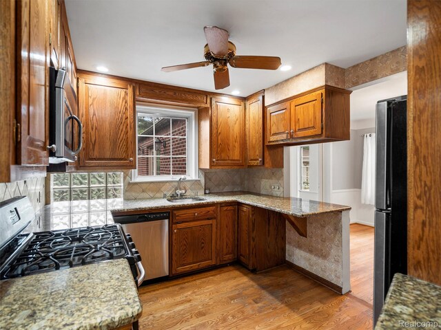 1930 Kenmore Dr, Grosse Pointe Woods, MI 48236 - kitchen with stainless steel microwave, gas range, dishwasher, freestanding refrigerator, and light stone counters
