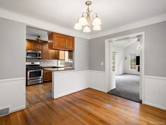 1930 Kenmore Dr, Grosse Pointe Woods, MI 48236 - kitchen with stainless steel appliances, backsplash, a chandelier, a peninsula, and wood finished floors