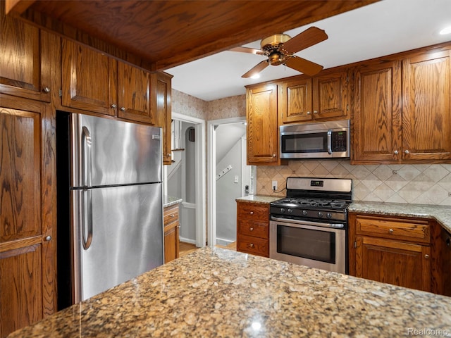 1930 Kenmore Dr, Grosse Pointe Woods, MI 48236 - kitchen featuring stainless steel appliances, tasteful backsplash, light stone countertops, brown cabinetry, and recessed lighting