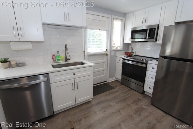 1670 Graefield Rd, Birmingham, MI 48009 - kitchen with appliances with stainless steel finishes, white cabinets, decorative backsplash, light countertops, and dark wood-style flooring