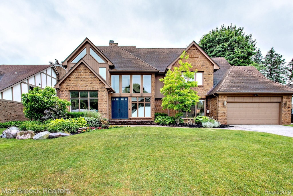 29921 Harrow Dr, Farmington, MI 48331 - english style home featuring brick siding, a front lawn, a garage, driveway, and a chimney