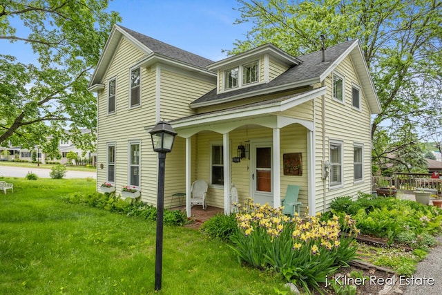 7115 Bronson St SE, Ada, MI 49301 - view of front of home with a front lawn, roof with shingles, and a porch